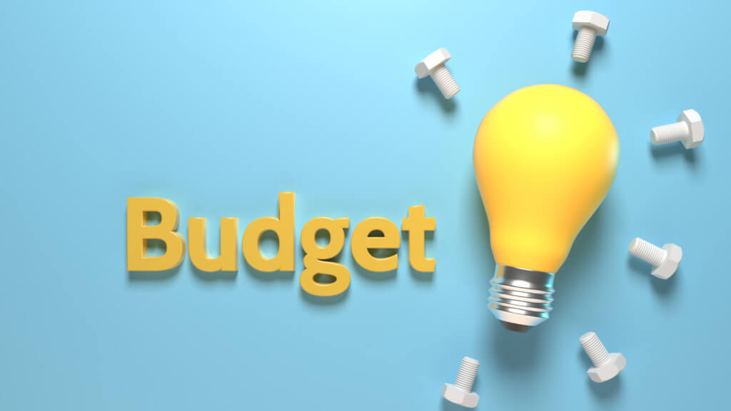 Blue background with a yellow lightbulb with screws around it saying "budget"