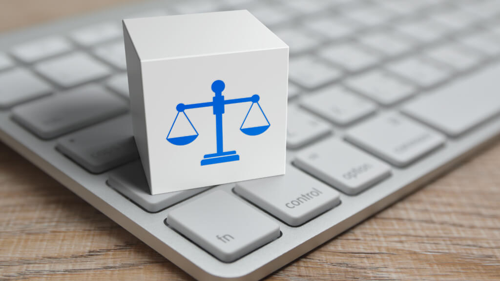 Legal scales on a box on a laptop to represent legal structure